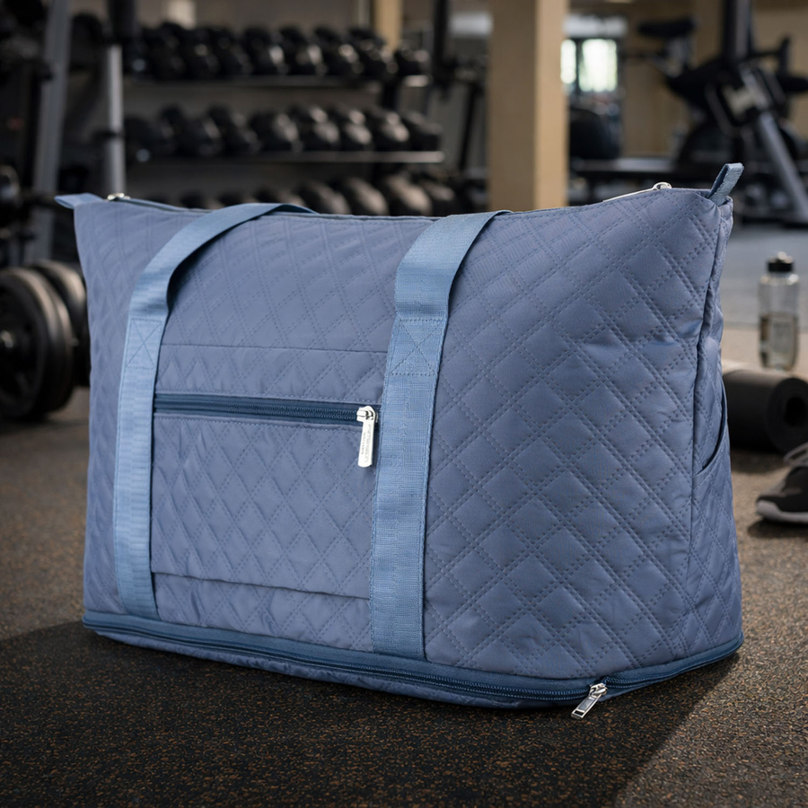 Treningowa torba wykonana z poliestru w niebieskim kolorze, wyposażona w uchwyt na walizkę - Peterson